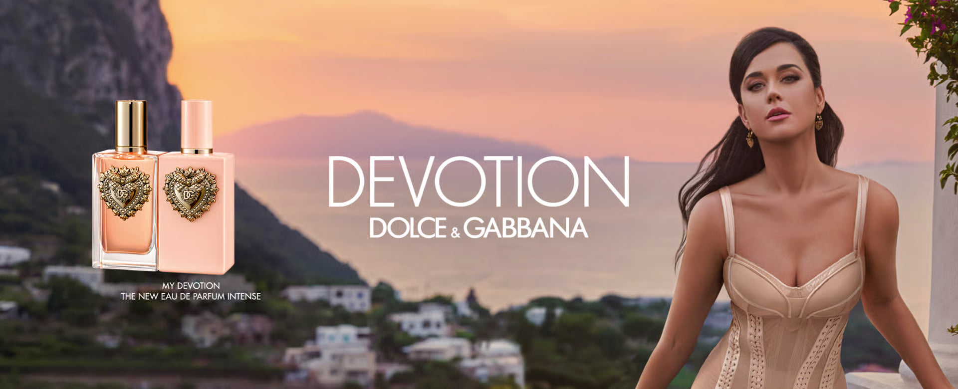 Una coppia in costume da bagno è distesa su un gommone bianco in mezzo al mare blu intenso, con scogli e faraglioni sullo sfondo. A destra, le bottiglie del profumo 'Light Blue' di Dolce & Gabbana per uomo e donna, con il logo del brand.